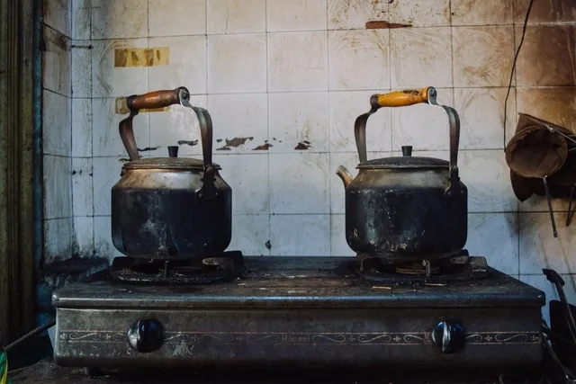 two cast iron kettles on a stove