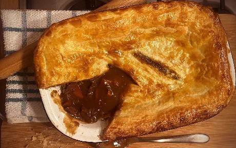 steak pie with gravy in a pie dish
